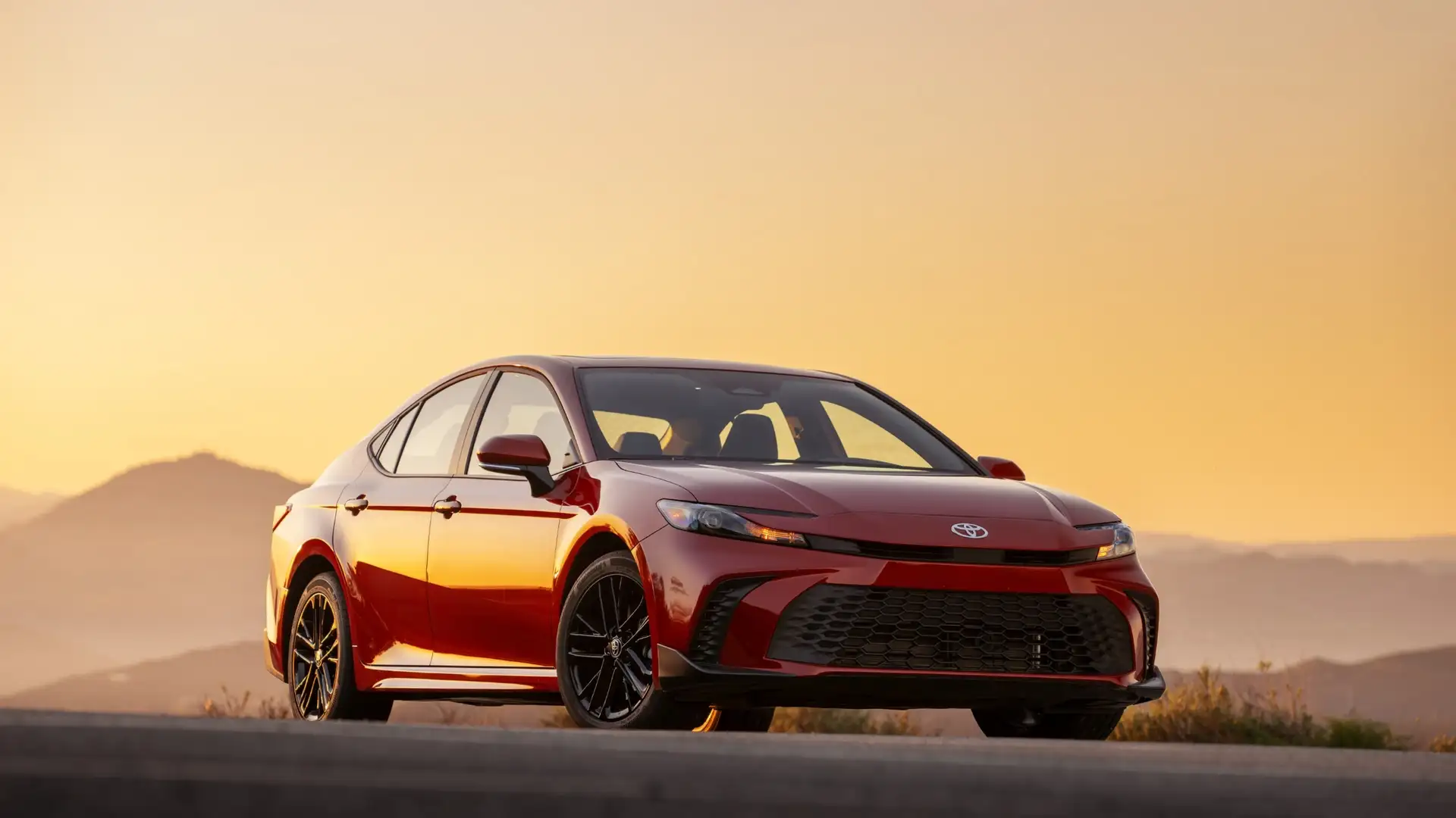 2026 Toyota Camry in Greencastle, PA displayed in red exterior with modern sedan styling, bold front grille, sleek headlights, and aerodynamic body design.