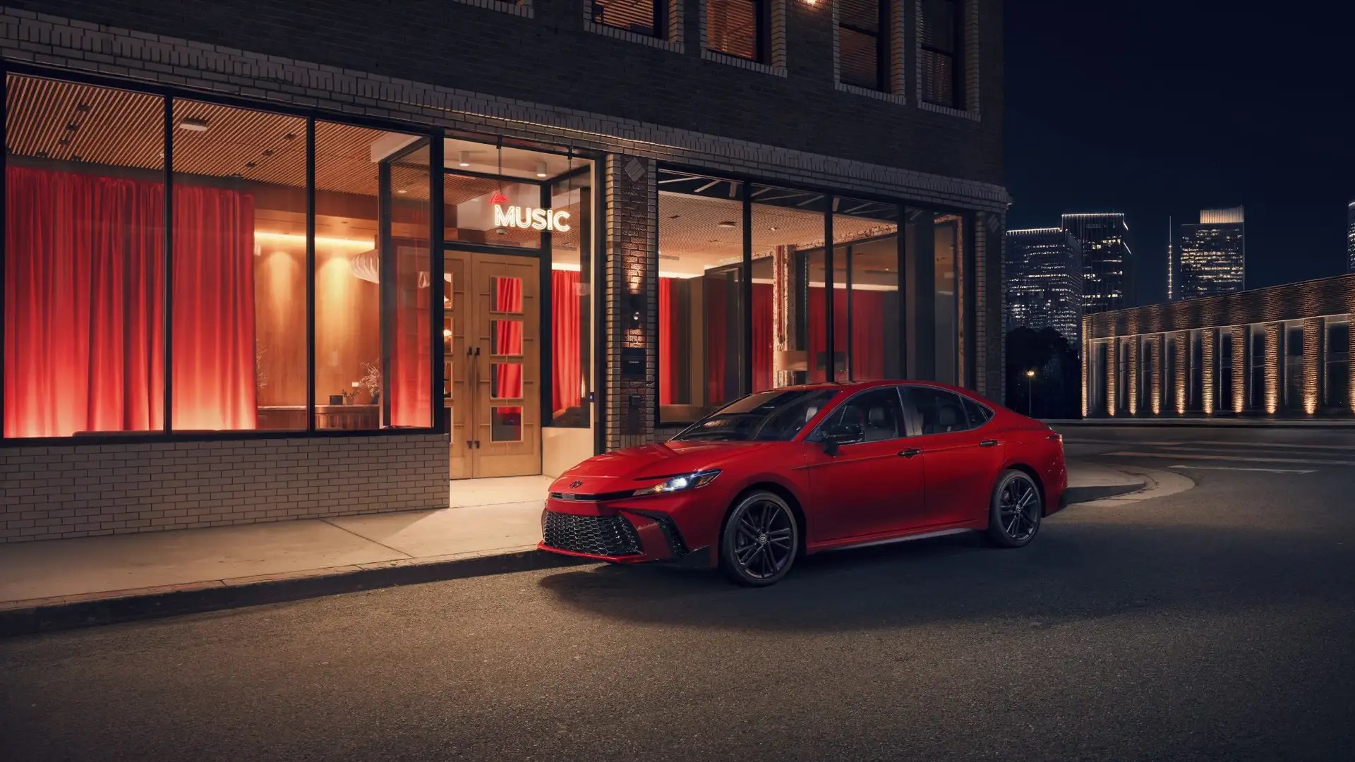 2026 Toyota Camry parked in an urban setting near Hagerstown, MD, displaying its modern sedan styling and refined exterior details.