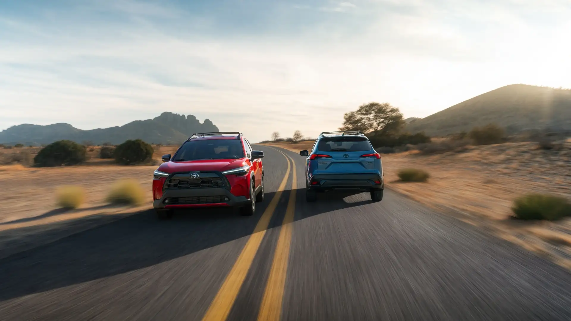 2026 Toyota Corolla Cross driving on an open road near Hagerstown, MD, emphasizing compact SUV versatility and modern styling.