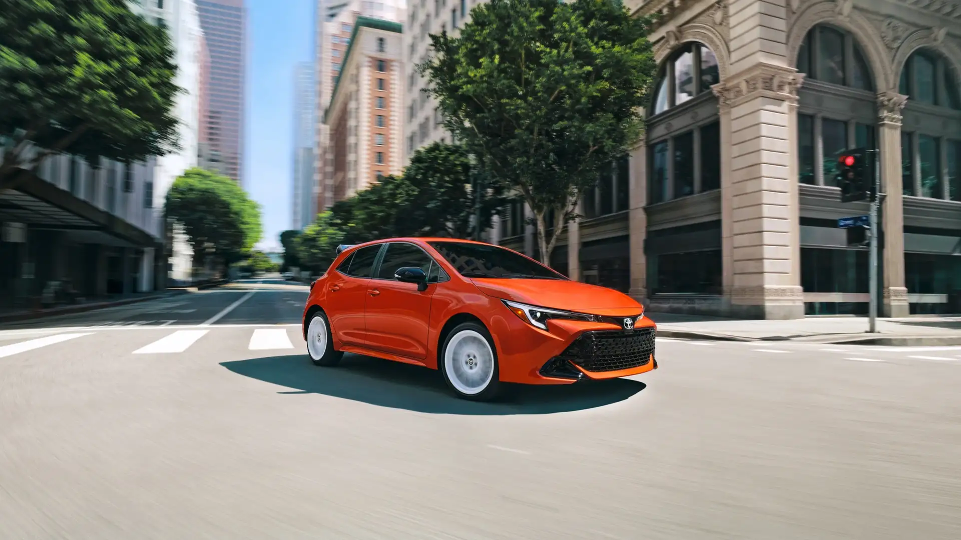 2026 Toyota Corolla Hatchback driving through a city street, highlighting sleek exterior design and urban driving performance near Hagerstown, MD.