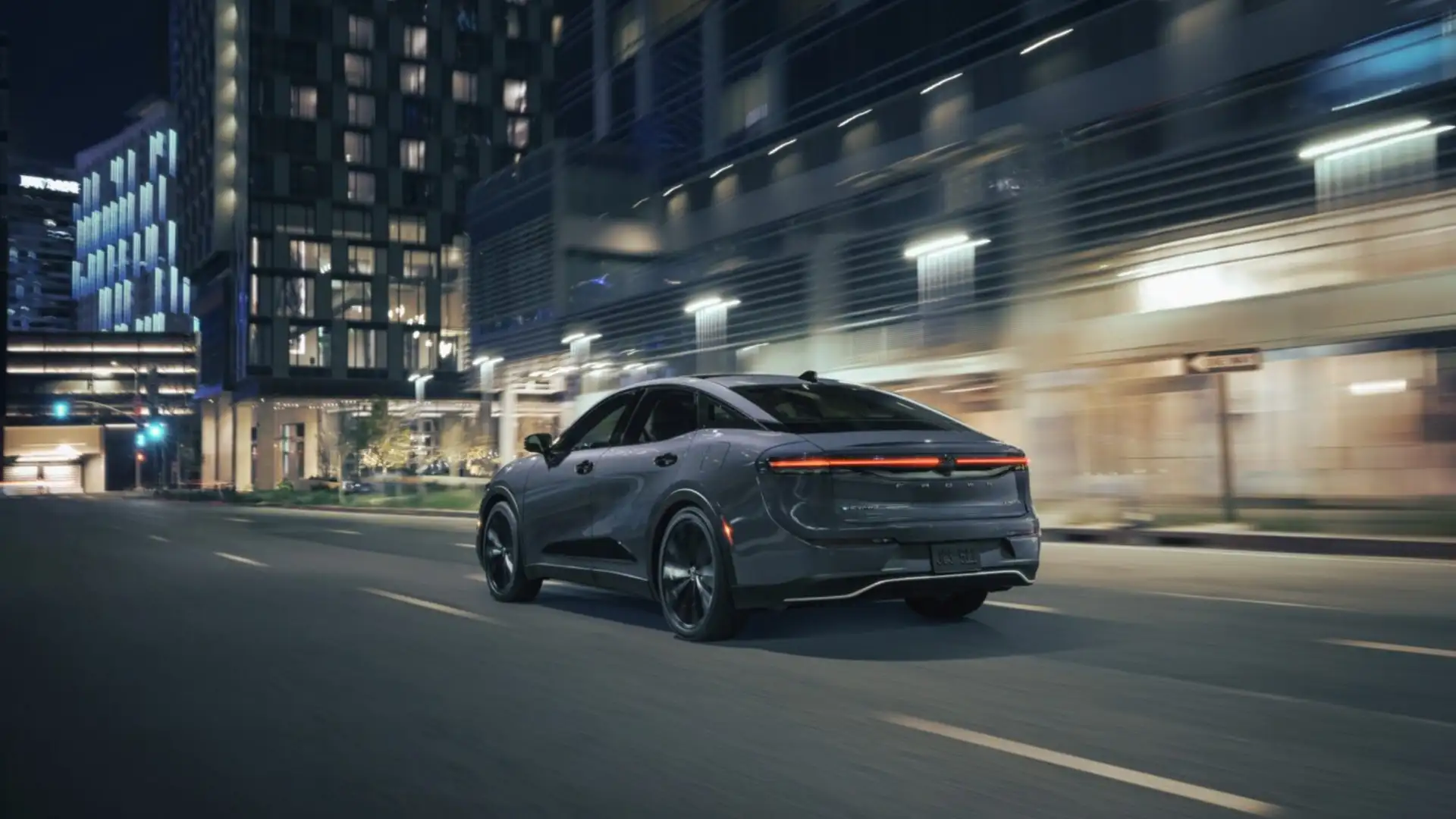 2026 Toyota Crown driving through a modern city at night, highlighting sleek exterior styling and smooth performance in Greencastle, PA.