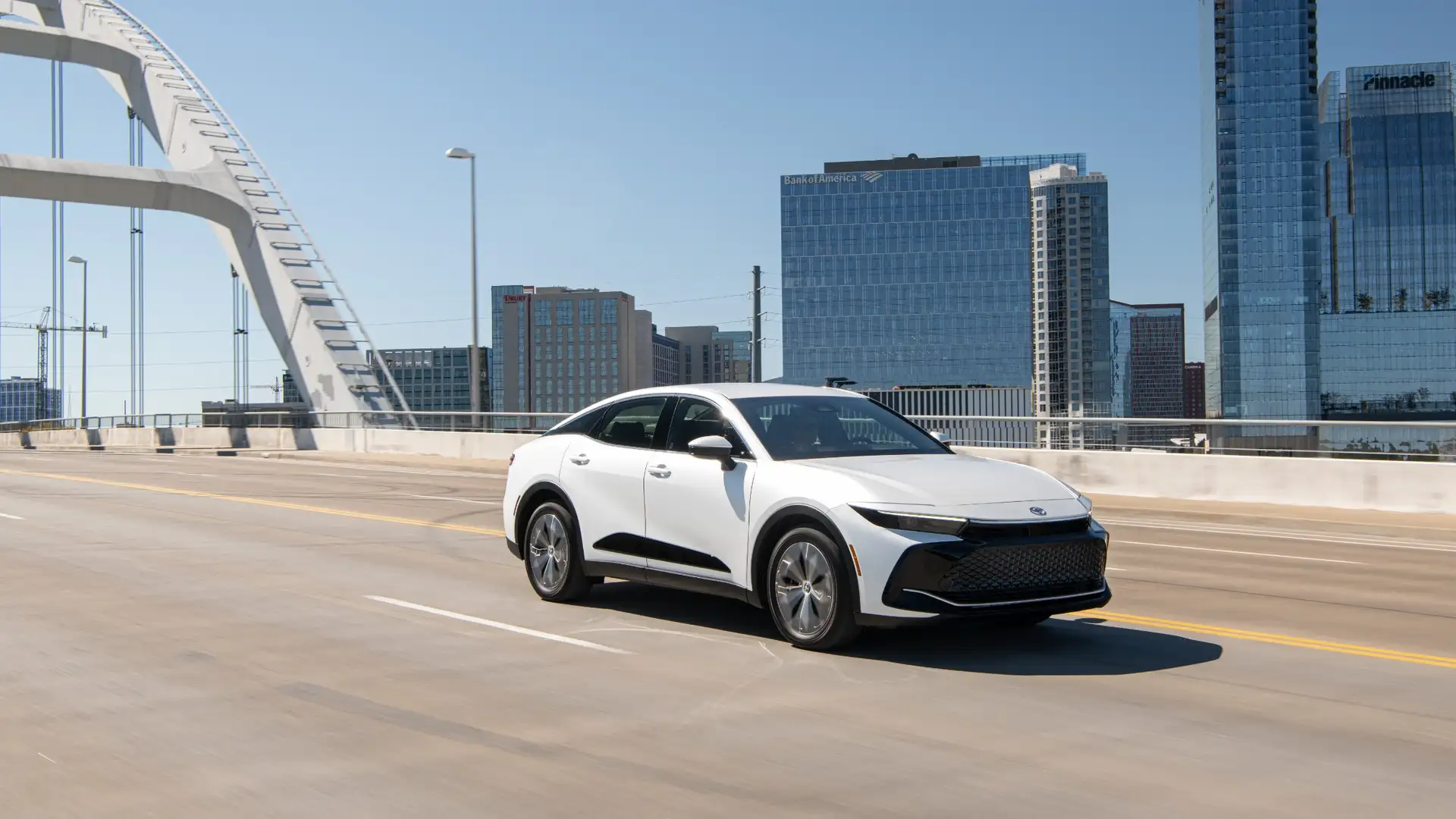 2026 Toyota Crown driving across a city bridge, highlighting sleek exterior styling and smooth performance near Hagerstown, MD.