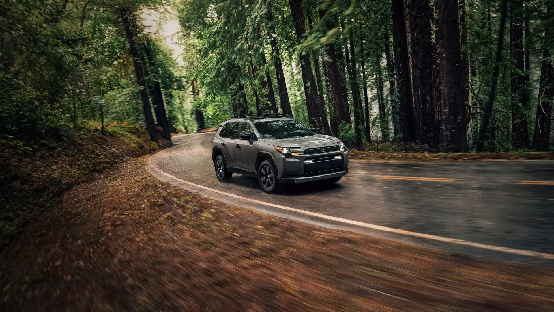 2026 Toyota RAV4 driving on a scenic road near Hagerstown, MD, showcasing its rugged exterior design and versatile SUV performance.