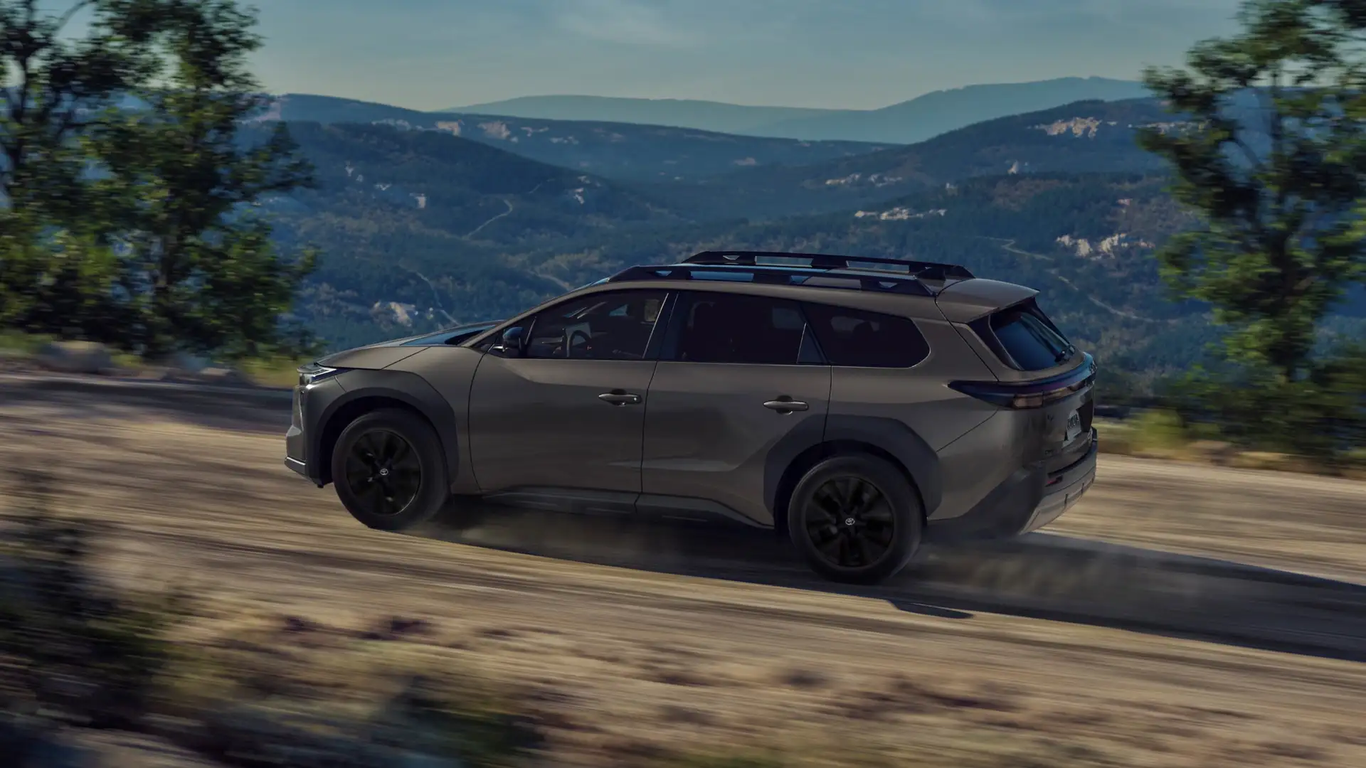 2026 Toyota bZ Woodland edition driving on a scenic road near Greencastle, PA, featuring rugged styling, roof rails, and outdoor-ready design