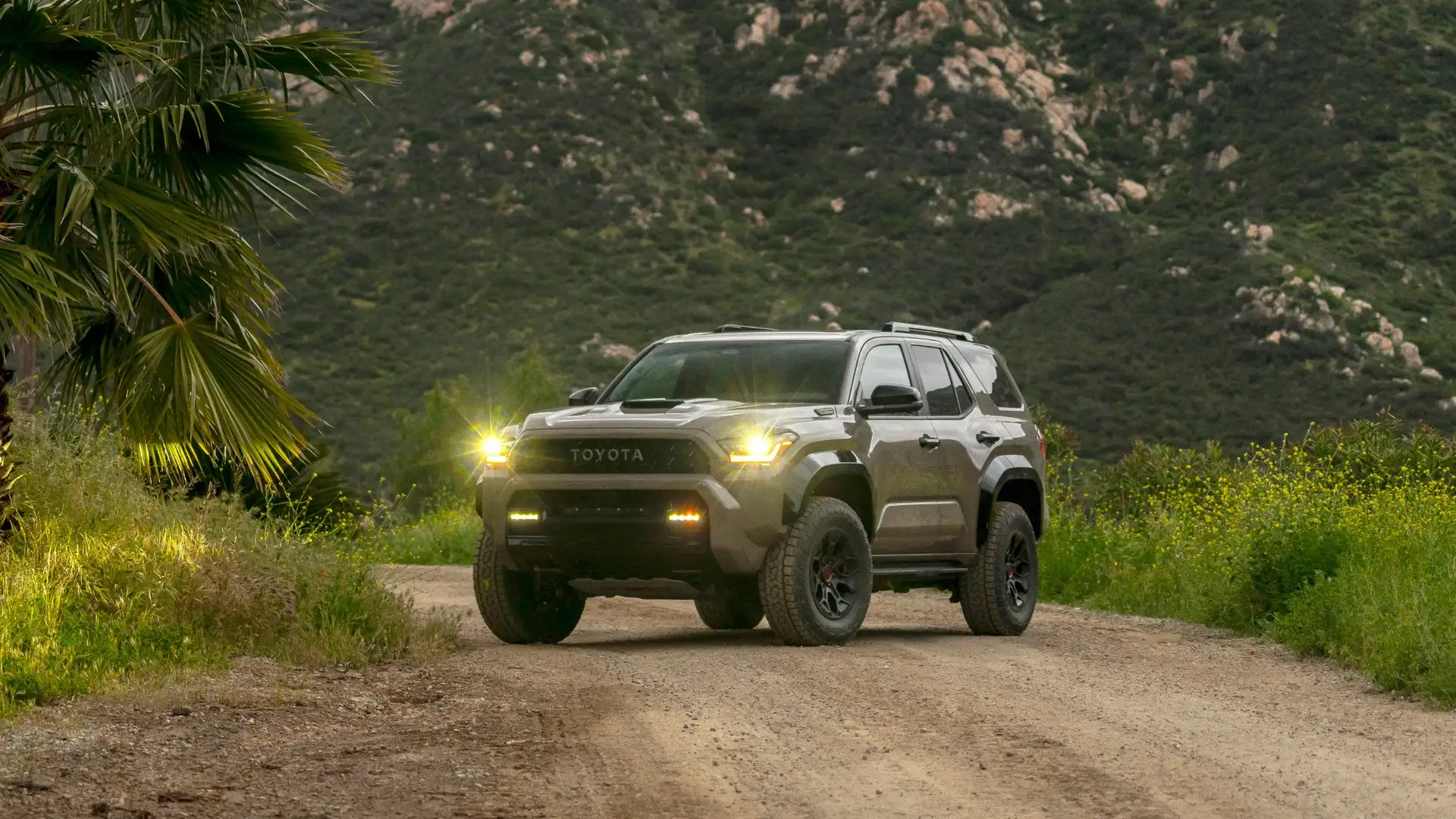 2024 Toyota 4Runner driving on a dirt road with headlights on, demonstrating adventure-ready performance for outdoor lifestyles in Hagerstown.