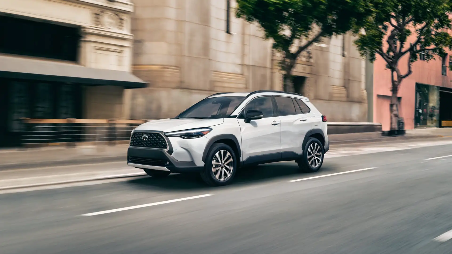 The 2025 Toyota Corolla Cross in Hagerstown, MD driving through a city street, highlighting its sleek exterior design, compact SUV profile, and smooth urban performance.