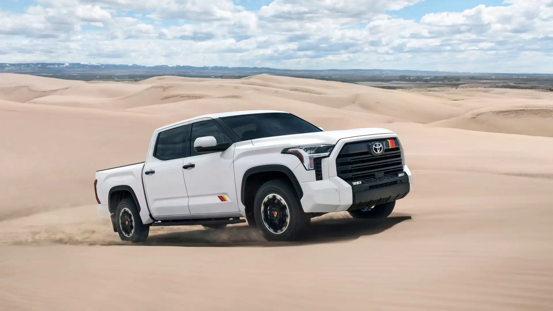 The 2025 Toyota Tundra in Hagerstown, MD driving across desert sand dunes, highlighting its powerful off road performance and rugged full size pickup truck design.