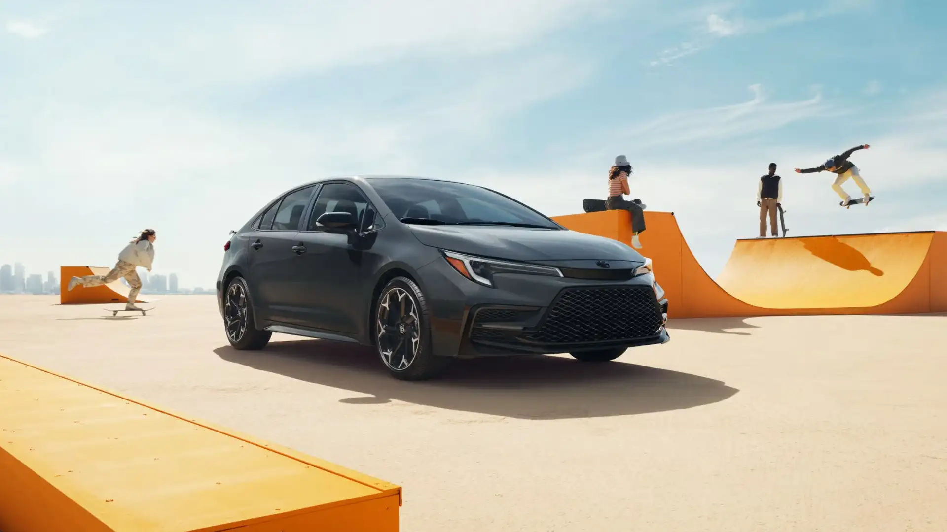 Dark gray 2025 Toyota Corolla Hybrid parked near a skate park, highlighting youthful design, efficiency, and eco-friendly appeal for Hagerstown drivers.