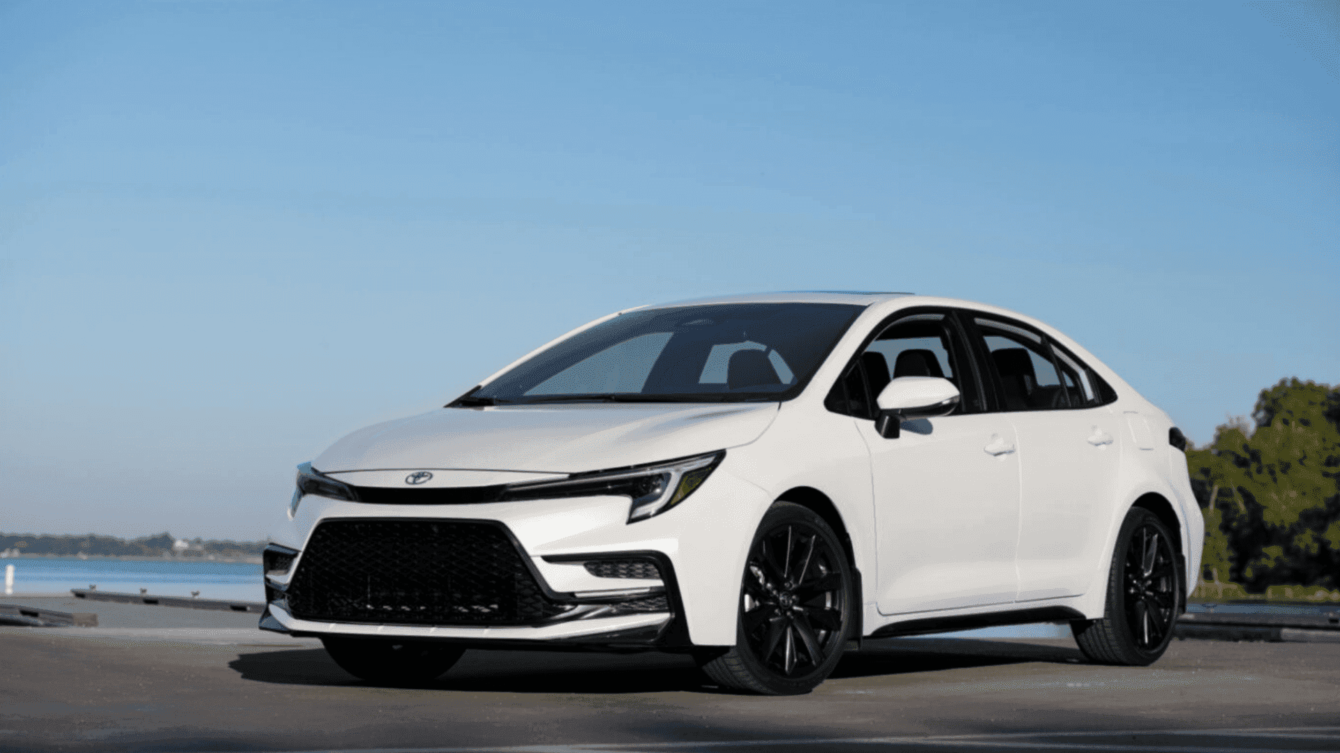 White 2026 Toyota Corolla sedan parked near a waterfront, showcasing sporty design and road trip readiness near Hagerstown, MD.