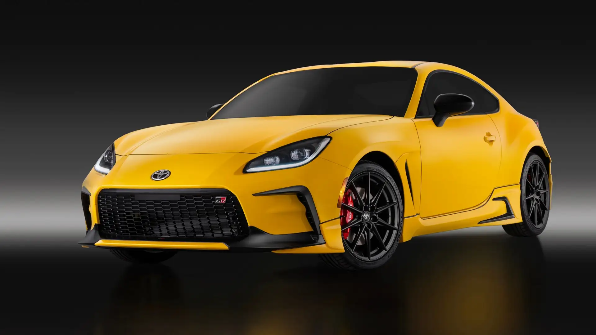 2026 Toyota GR86 in yellow with red Brembo brakes and black wheels on a studio background, available in Hagerstown MD