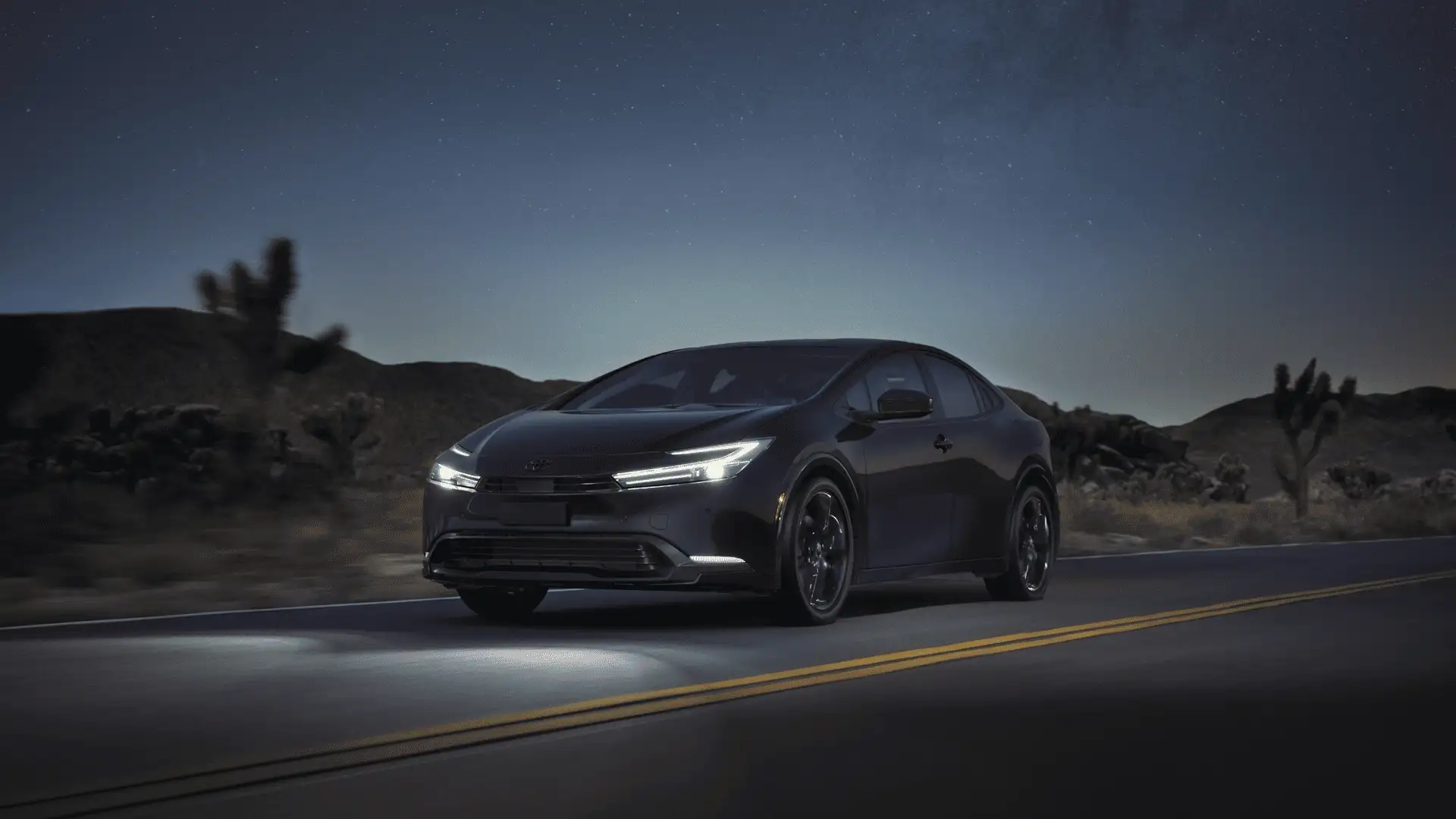 Black 2026 Toyota Prius Plug-in Hybrid driving desert road in Hagerstown MD