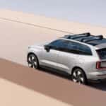 2025 Volvo EX90 electric SUV rear three quarter view driving on minimalist concrete roadway