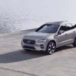 2025 Volvo XC60® hybrid SUV front three-quarter view in silver parked near waterfront