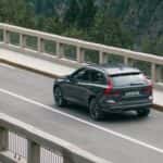 2026 Volvo XC60 Plug-In Hybrid rear three-quarter view driving on bridge in gray